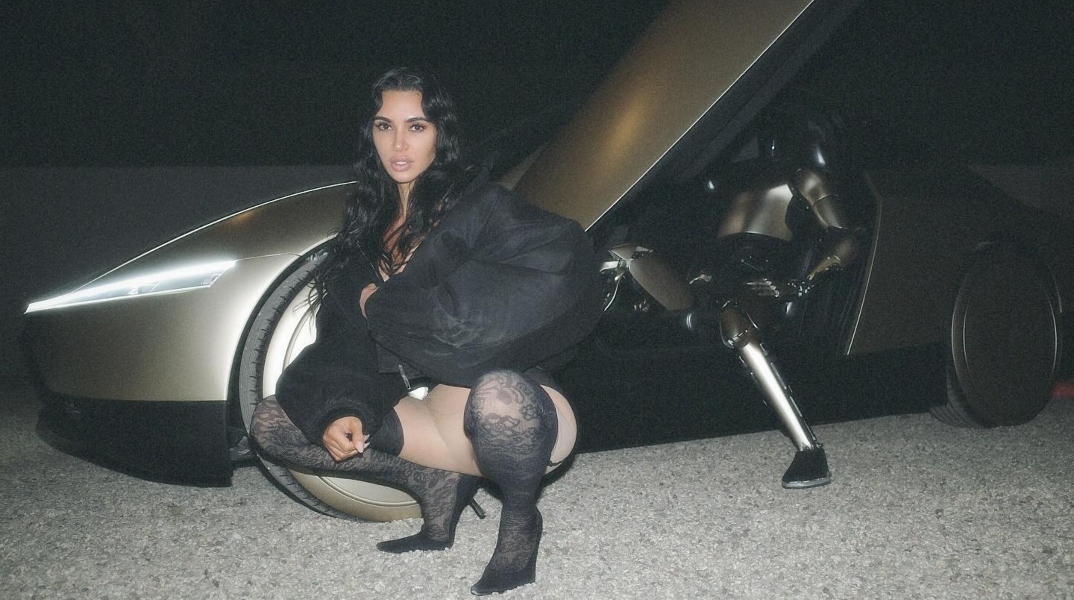 Η Κιμ Καρντάσιαν μπροστα σε αυτοκινητο Tesla, ρομποτ