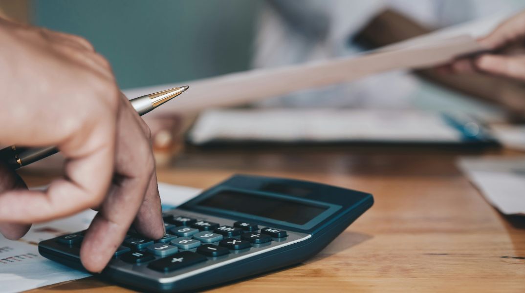 Άτομο που πληκτρολογεί σε αριθμομηχανή