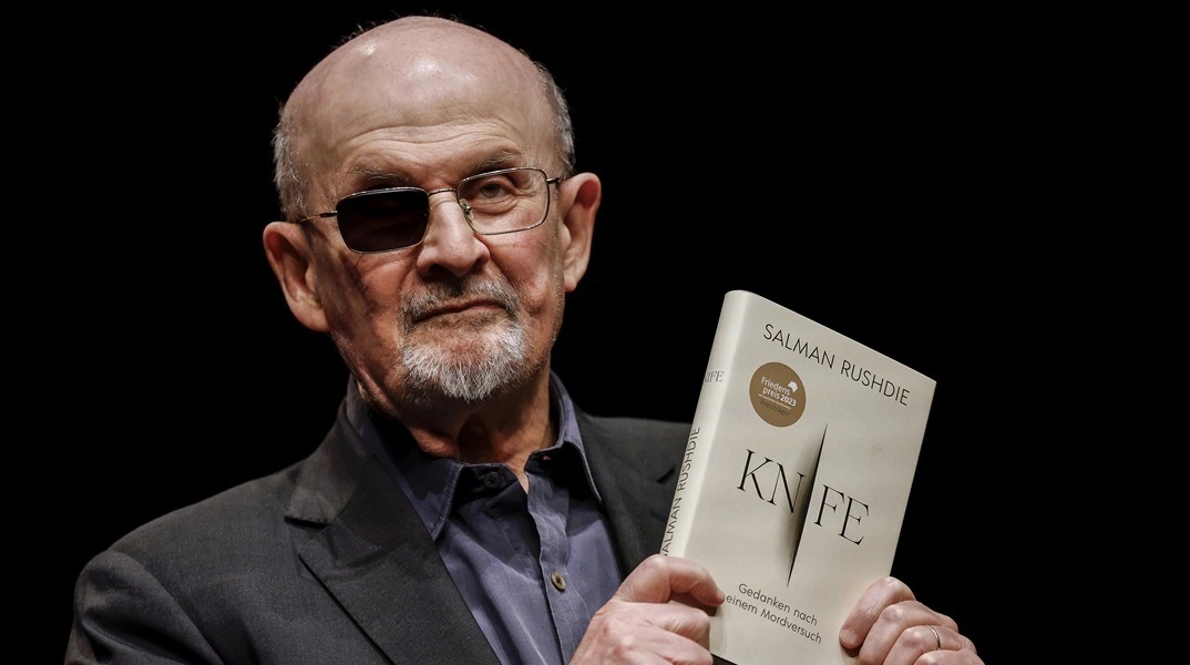 Ο Σαλμάν Ρούσντι κρατώντας βιβλίο