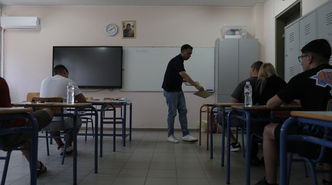 Επιτηρητής μοιράζει τις κόλλες με τα θέματα στους υποψηφίους των ΕΠΑΛ των Πανελληνίων 2025