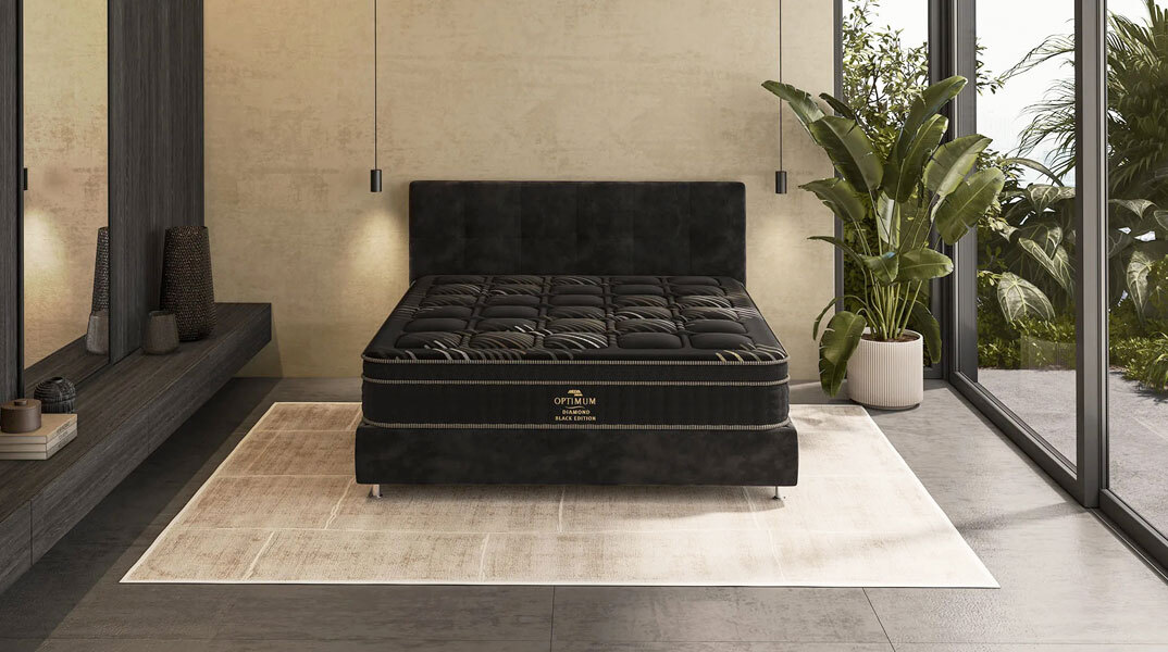 Πολυτελές διπλό κρεβάτι με μαύρο στρώμα Media Strom σε κομψό υπνοδωμάτιο με φυσικό φωτισμό και πράσινα φυτά