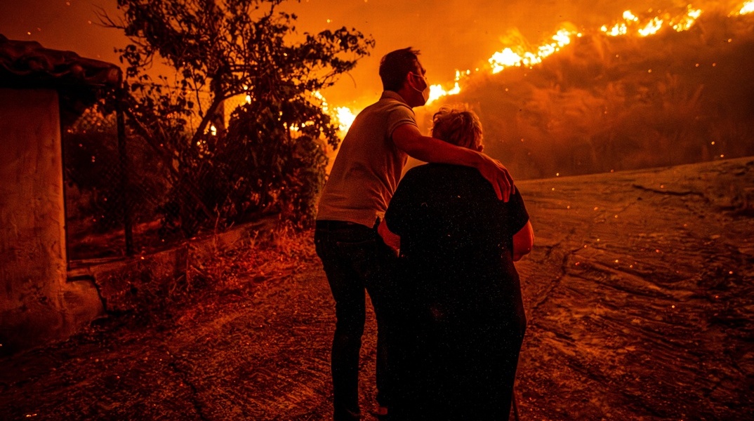 Άνδρας απομακρύνει γυναίκα από το σημείο της φωτιάς στην Αρχαία Ολυμπία