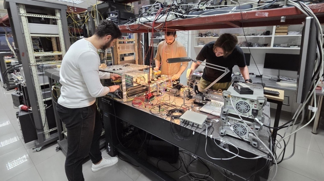 Τα μέλη της ερευνητικής ομάδας του Τμ. Πληροφορικής που πραγματοποιούν την πειραματική υλοποίηση για τον φωτονικό επεξεργαστή Τεχνητής Νοημοσύνης. Διακρίνονται από αριστερά οι υποψήφιοι διδάκτορες Αντώνης Πράπας, Μόσχος Θεόδωρος, Οδυσσέας Ασημόπουλος