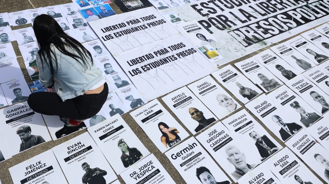 Ένα άτομο κοιτάζει εικόνες πολιτικών κρατουμένων κατά τη διάρκεια διαμαρτυρίας στην Plaza del Rectorado UCV στο Καράκας, Βενεζουέλα