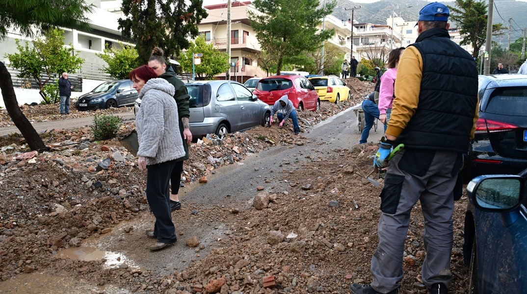 Πολίτες απομακρύνουν πέτρες από τον δρόμο