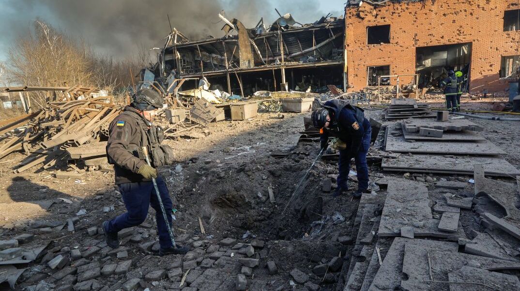 Ουκρανοί ειδικοί πυροτεχνουργοί περιεργάζονται κρατήρα βόμβας στο Μπρόβαρυ, κοντά στο Κίεβο