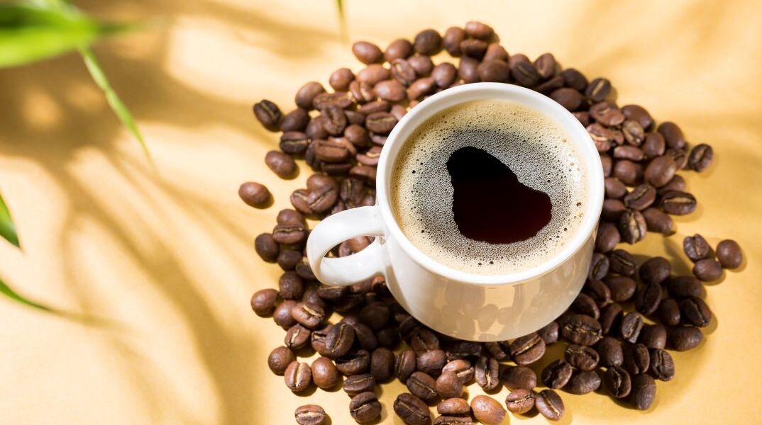 Μια κούπα καφέ, ανάμεσα σε κόκκους