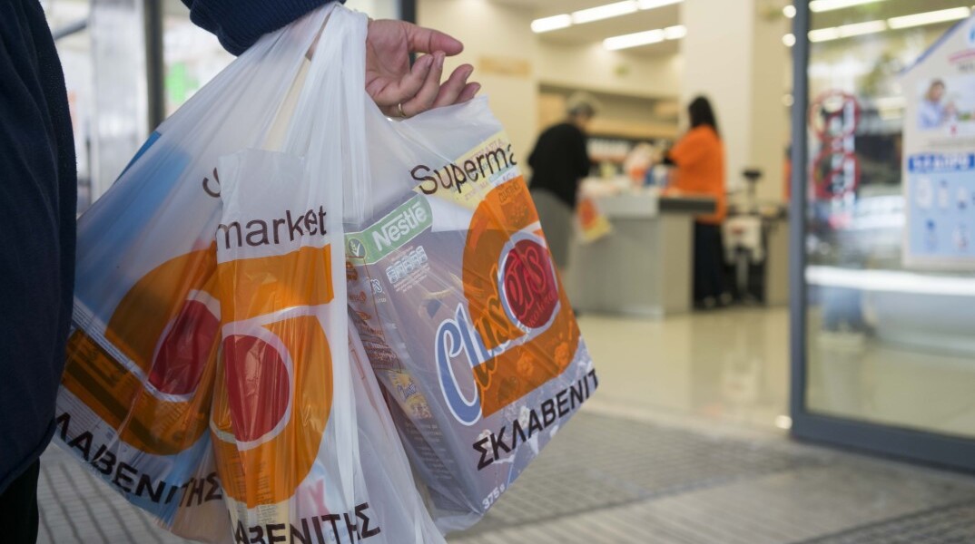Καταναλωτής με ψώνια στο χέρι έξω από σούπερ μάρκετ «Σκλαβενίτης»