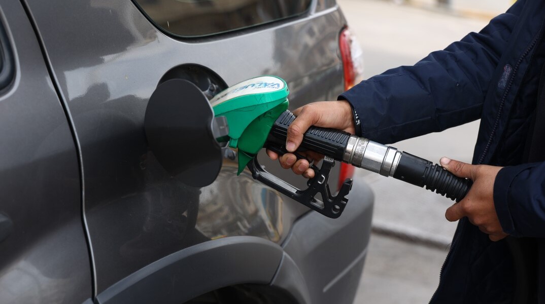Υπάλληλος σε βενζινάδικο βάζει βενζίνη σε όχημα