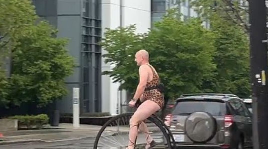 Σιάτλ σε άλλη διάσταση: Άνδρας με λεοπάρ κορμάκι έκανε βόλτα με βικτωριανό ποδήλατο μέσα στη βροχή