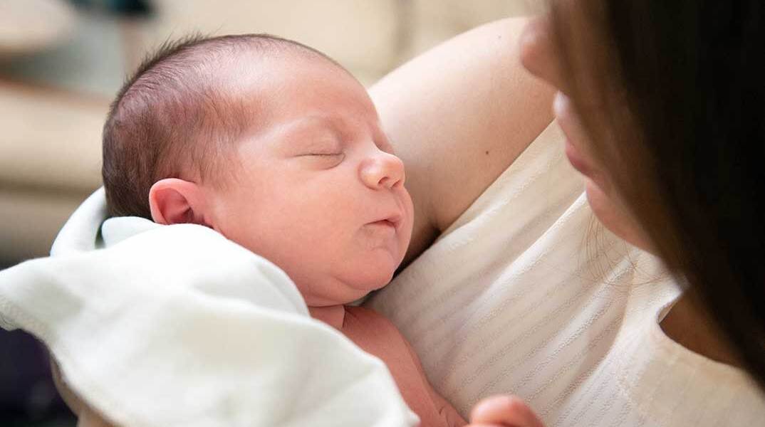 Μητέρα κρατά το νεογέννητο παιδί της στην αγκαλιά