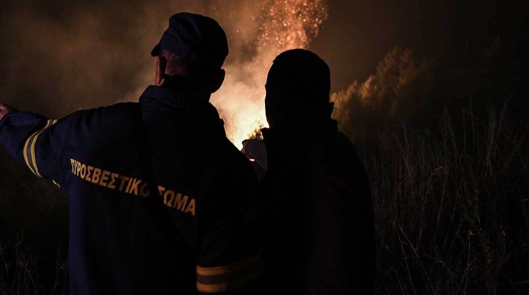 Πυροσβέστες μπροστά στις φλόγες κατά τη διάρκεια της νύχτας