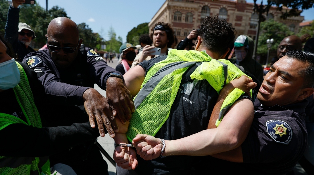 Αστυνομικοί συλλαμβάνουν διαδηλωτή με χειροπέδες