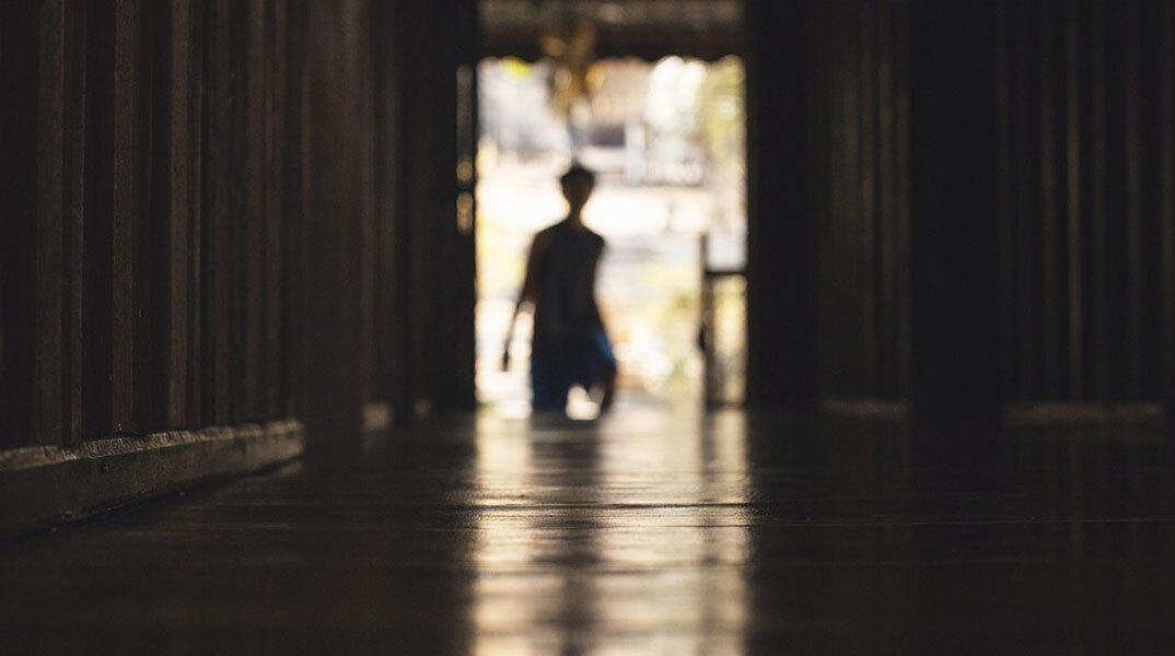 Νεαρό αγόρι στο βάθος διαδρόμου - Φωτογραφία που παραπέμπει σε μυστήριο και κακοποίηση