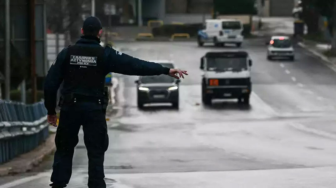Αστυνομικός κάνει σήμα σε οδηγό να σταματήσει για έλεγχο