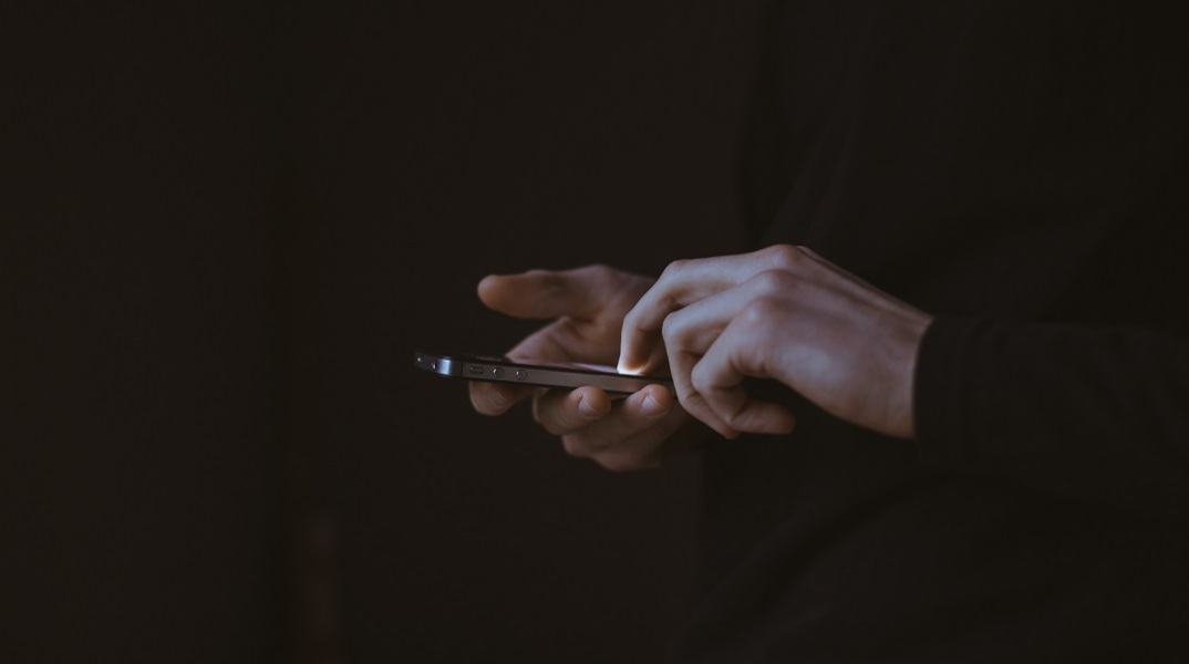 Χέρια πληκτρολογούν σε τηλέφωνο