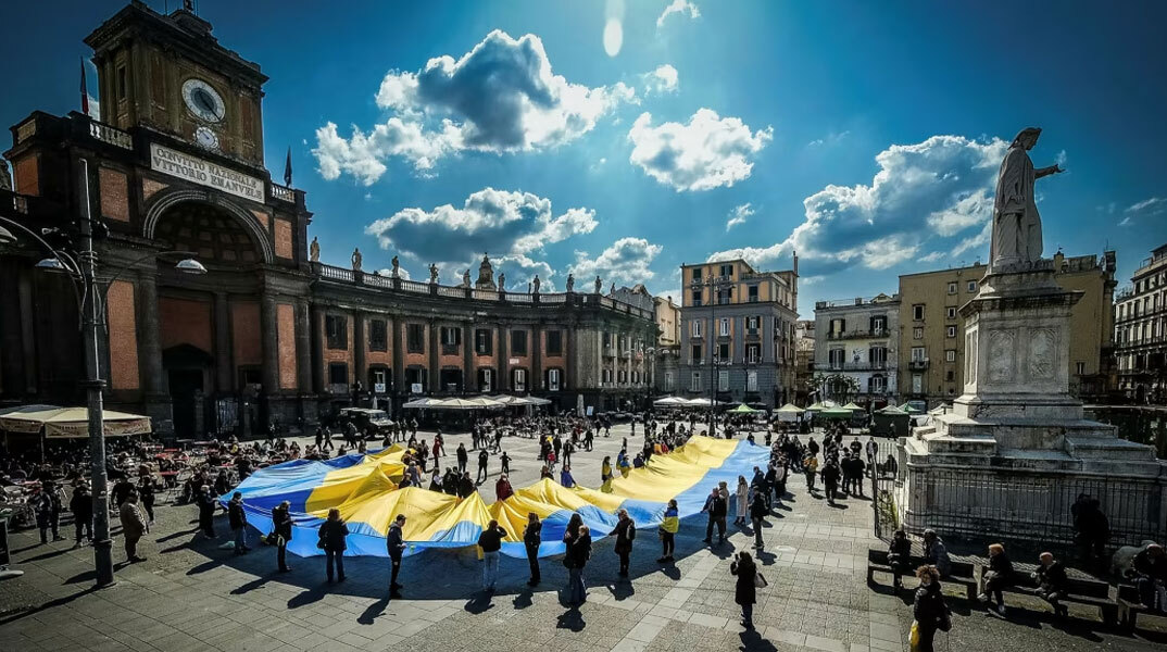 Ουκρανοί που ζουν στη Νάπολη, κρατούν την ουκρανική σημαία σε συγκέντρωση στο κέντρο της ιταλικής πόλης