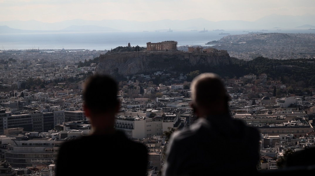 Άνθρωποι στον λόφο του Λυκαβηττού που κοιτούν τη θέα της Ακρόπολης