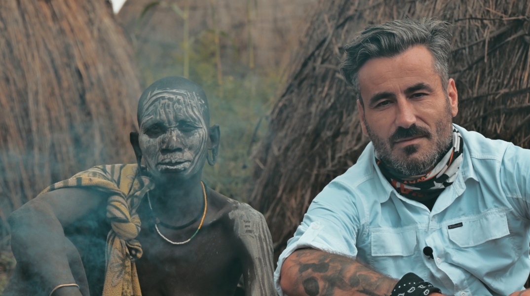 Ο Γιώργος Μαυρίδης μαζί με μέλος της φυλής Μούρσι στην Αιθιοποιία, στα γυρίσματα της εκπομπής Into The Skin