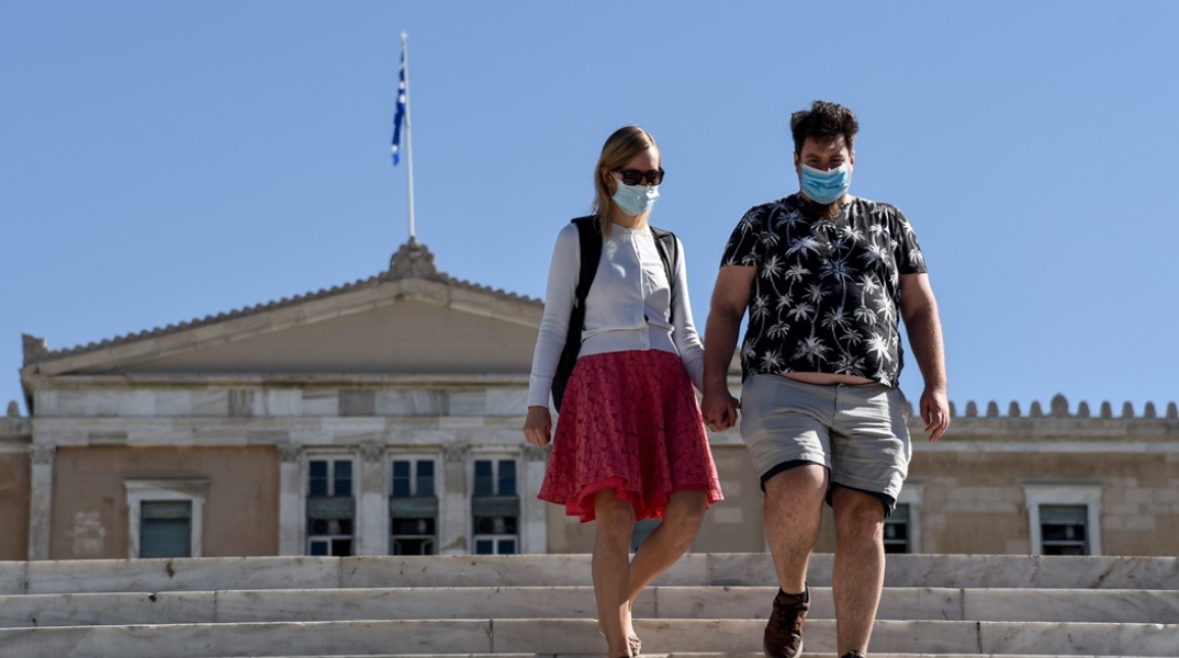 Ζευγάρι με μάσκα στο κέντρο της Αθήνας - Περπατούν με φόντο τη Βουλή