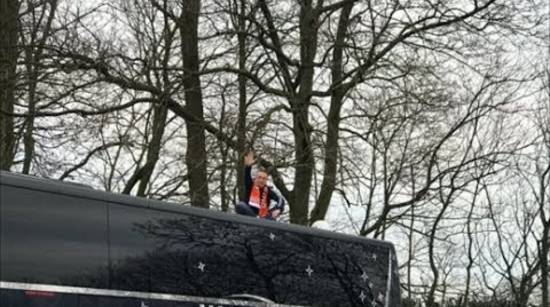 Blackpool fan sits on top of Arsenal's bus in Oyston protest