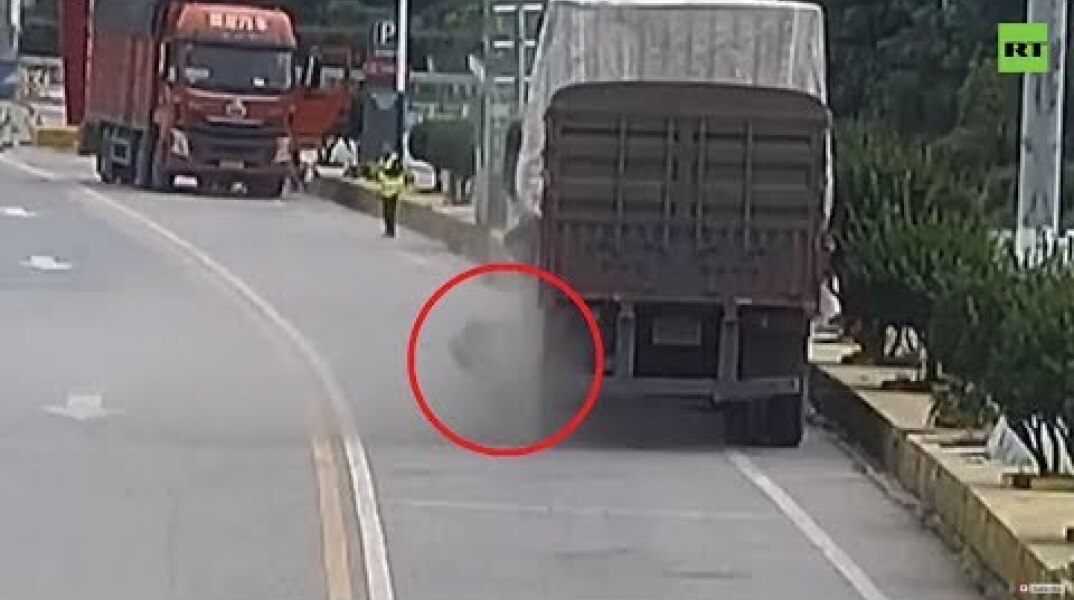 Moment truck tire explodes as Chinese driver tries to fix it (DISTURBING)