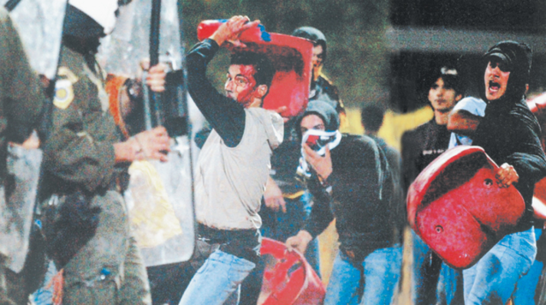 Αθήνα 1997. Αστυνομικοί σέρνουν οπαδό του Παναθηναϊκού τραβώντας τον από το κασκόλ, ύστερα από βίαια επεισόδια στο ποδοσφαιρικό ντέρμπι Ολυμπιακού-Παναθηναϊκού. Φωτό: Γρηγόρης Χρυσοχοίδης