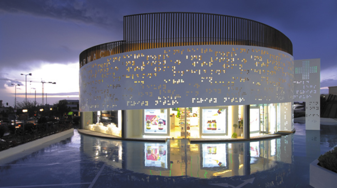 Placebo Pharmacy, Λεωφ. Βουλιαγμένης. «…Τα μεταλλικά πανέλα της πρόσοψης είναι διάτρητα με λέξεις γραμμένες με το σύστημα Μπράιγ, το οποίο χρησιμοποιείται στα φαρμακευτικά προϊόντα…»