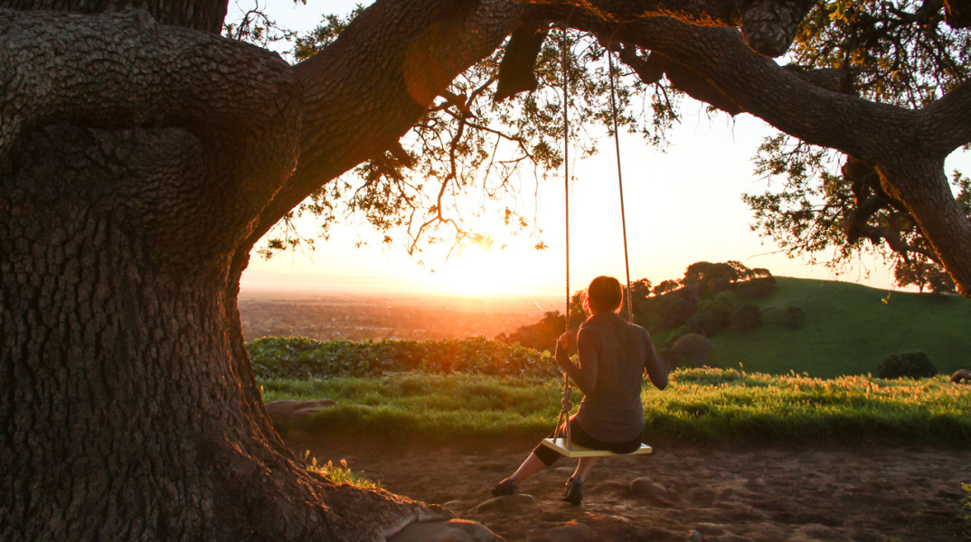 girl-on-swing-under-tree-watching-sunrise.jpg