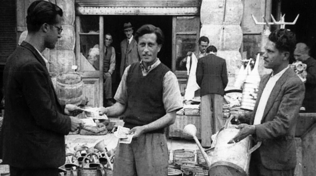 Εκτεθειμένα προϊόντα στην οδό Αθηνάς από το εργαστήριο λευκοσιδηρουργίας του Γιώργου Τερρίκογλου (μεσαίος). Περίοδος Κατοχής