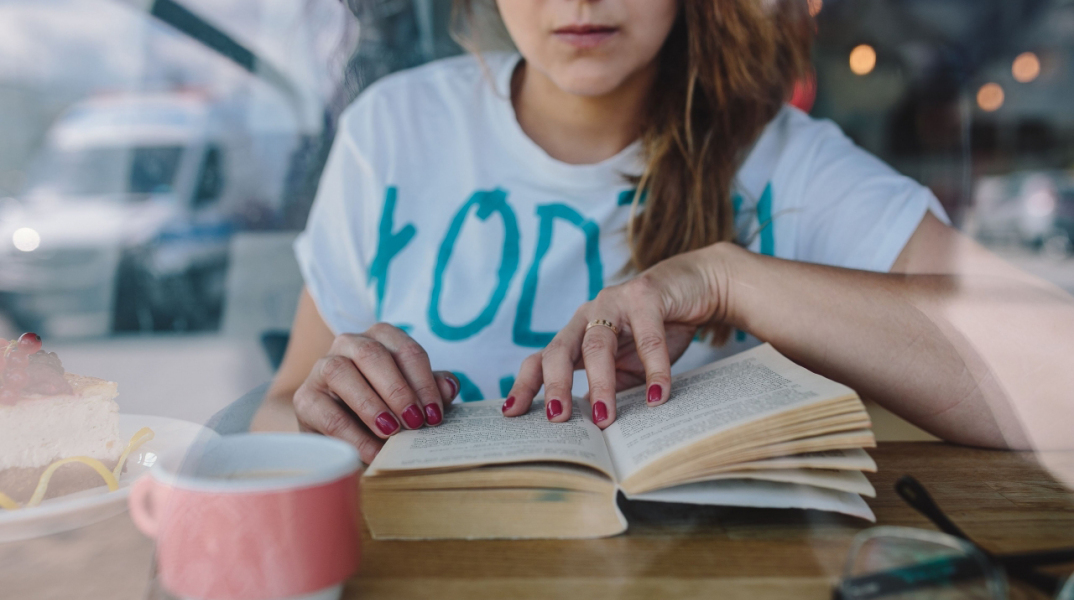 kaboompics_woman_reading_book_at_coffee_shop.jpg