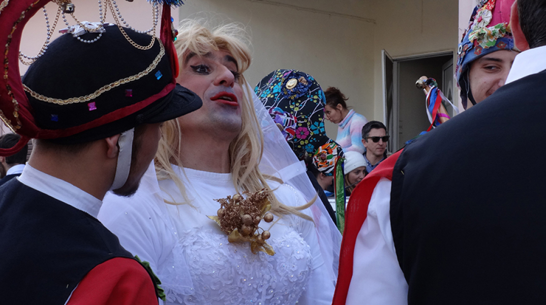 Οι Μωμόγεροι μεταμφιεσμένοι χορεύουν και τραγουδούν στους δρόμους