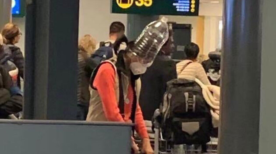 Κοροναϊός: Κινέζα τουρίστρια με προστατευτική μάσκα και πλαστικό μπουκάλι στο κεφάλι