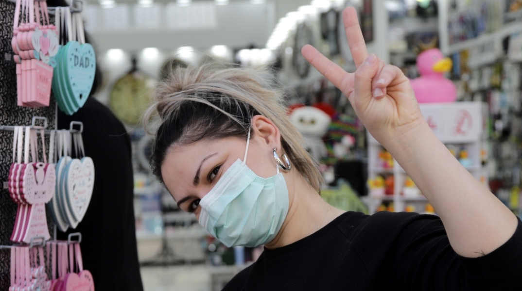 Κοπέλα με μάσκα κάνει το σήμα της νίκης 