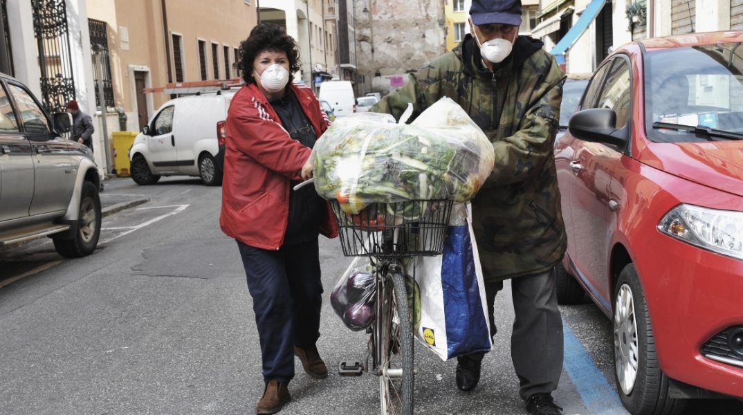 Ζευγάρι με μάσκες προστασίας από τον κορωνοϊό στο δρόμο