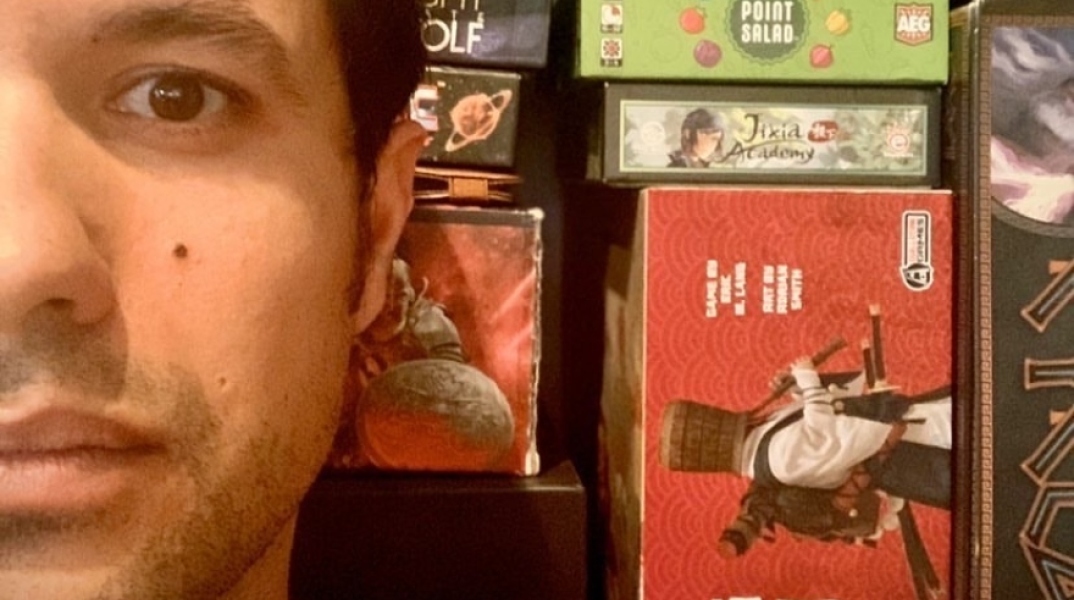 Ο Ορφέας Αυγουστίδης μπροστά από τα επιτραπέζια που μας προτείνει για όσο Μένουμε Σπίτι