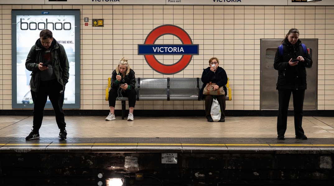 Τέσσερις άνθρωποι περιμένουν στο σταθμό Victoria του μετρό του Λονδίνου