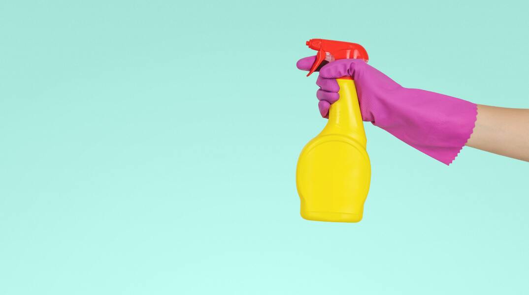 Γυναικείο χέρι ψεκάζει με ένα μπουκάλι απορρυπαντικού