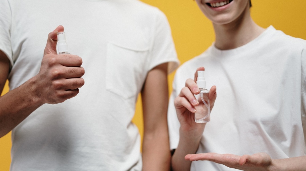 Άντρας και γυναίκα κρατούν στα χέρια μπουκαλάκια με διάφανο υγρό