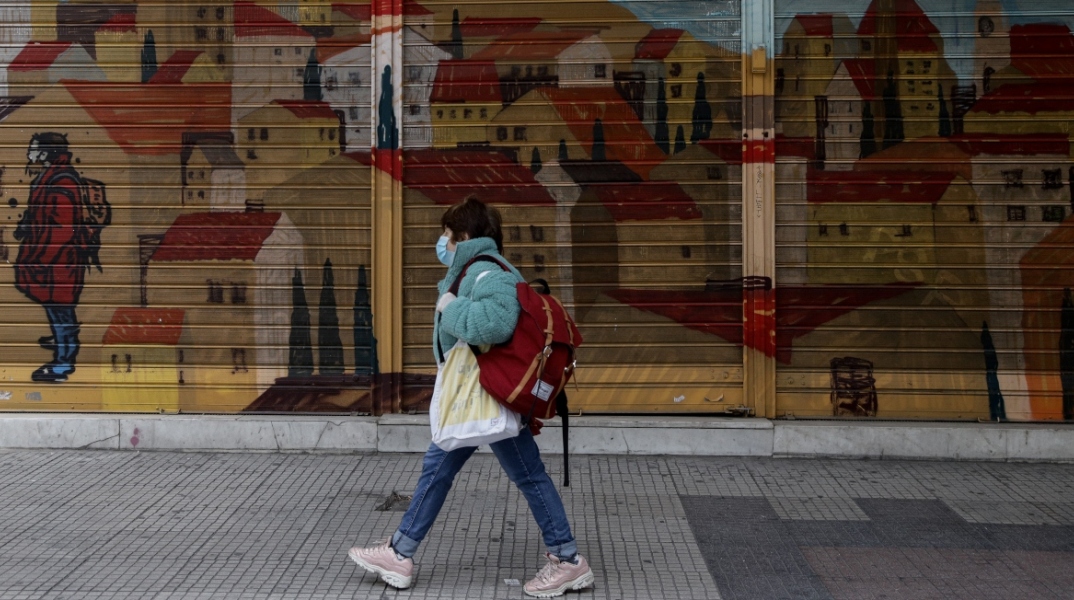 Γυναίκα περπατάει με μάσκα στο κέντρο της Αθήνας