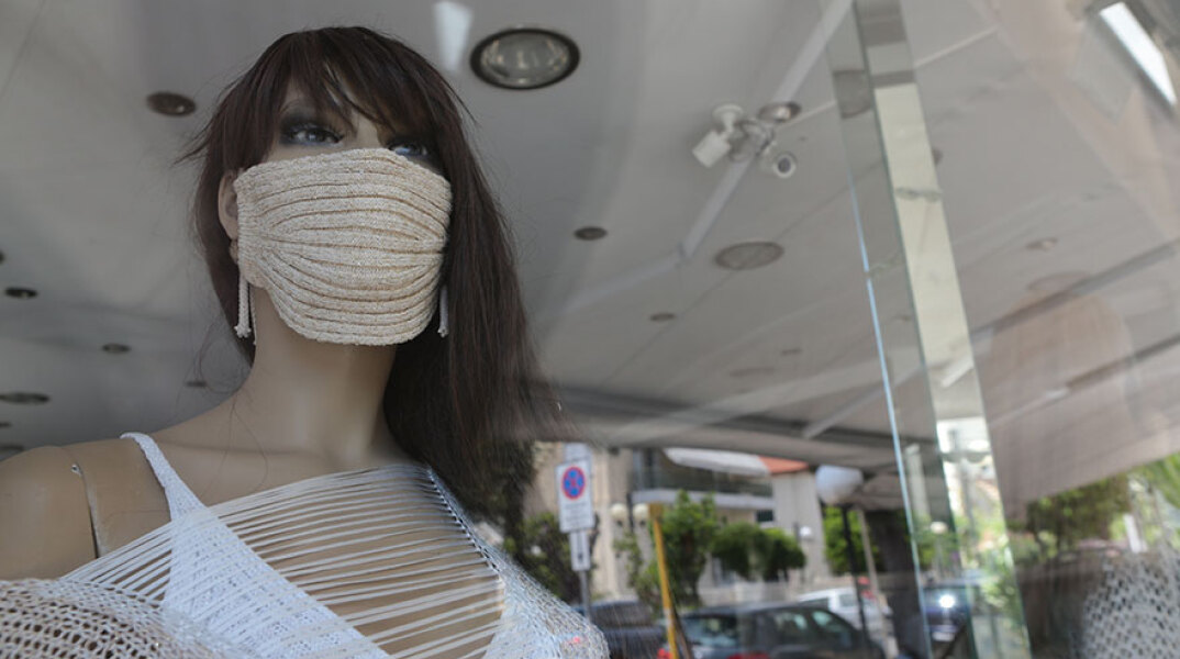 Κούκλα βιτρίνας καταστημάτων ρούχων με μάσκα λόγω κορωνοϊού
