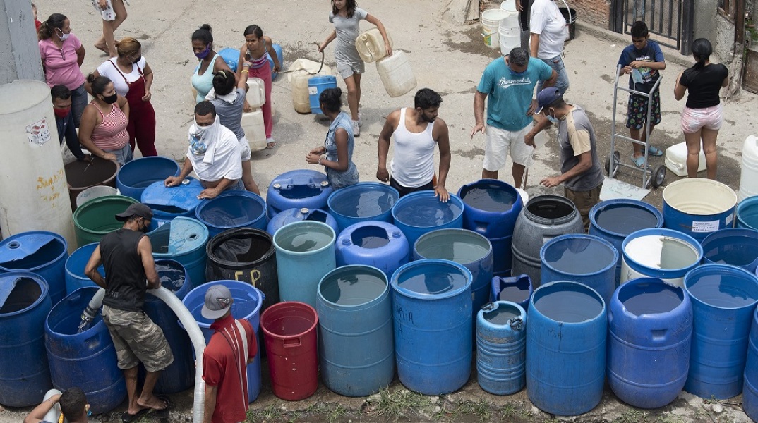 Άνθρωποι στη Βενεζουέλα προσπαθούν να γεμίσουν βαρέλια με νερό εν μέσω πανδημίας του κορωνοϊού