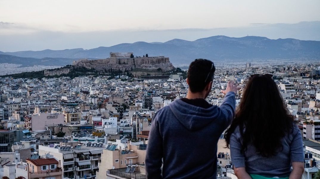 Δύο νέοι κοιτούν τη θέα της Αθήνας