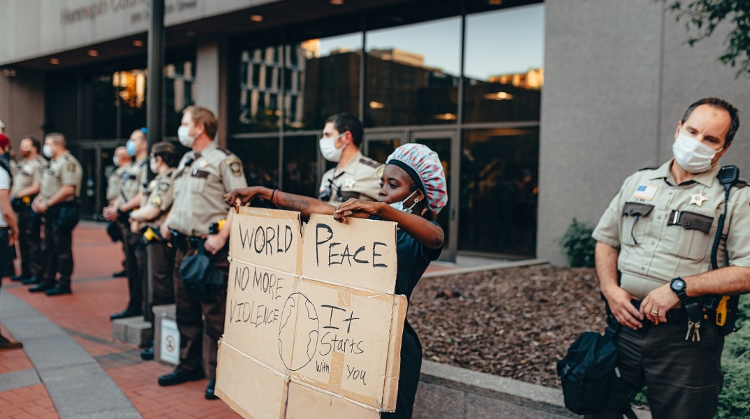 Έφηβη αφροαμερικανή που κρατά πλακάτ διαμαρτυρίας στη Μινεάπολη για τον βίαιο θάνατο του Τζορτζ Φλόιντ
