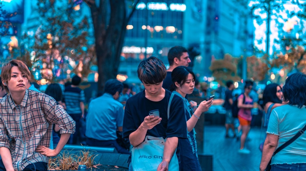 Άνθρωποι κοιτούν τα κινητά τους