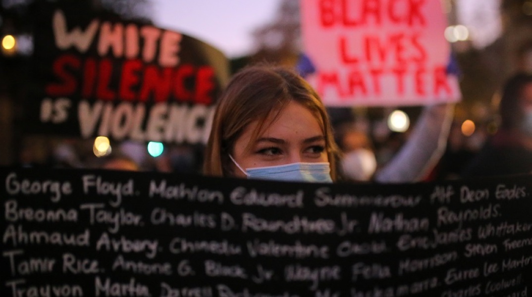 Μία κοπέλα κρατάει ένα πανό 