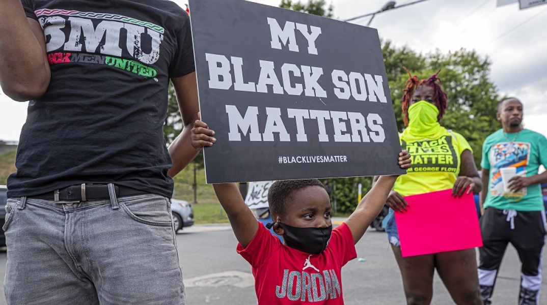 Ένα μικρό παιδί στις ΗΠΑ κρατάει πανό κατά του ρατσισμού