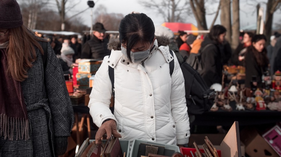 Μία κοπέλα στο Βερολίνο ψωνίζει βιβλία με μάσκα