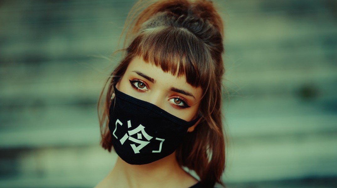 Κοπέλα φοράει μάσκα για τον κορωνοϊό