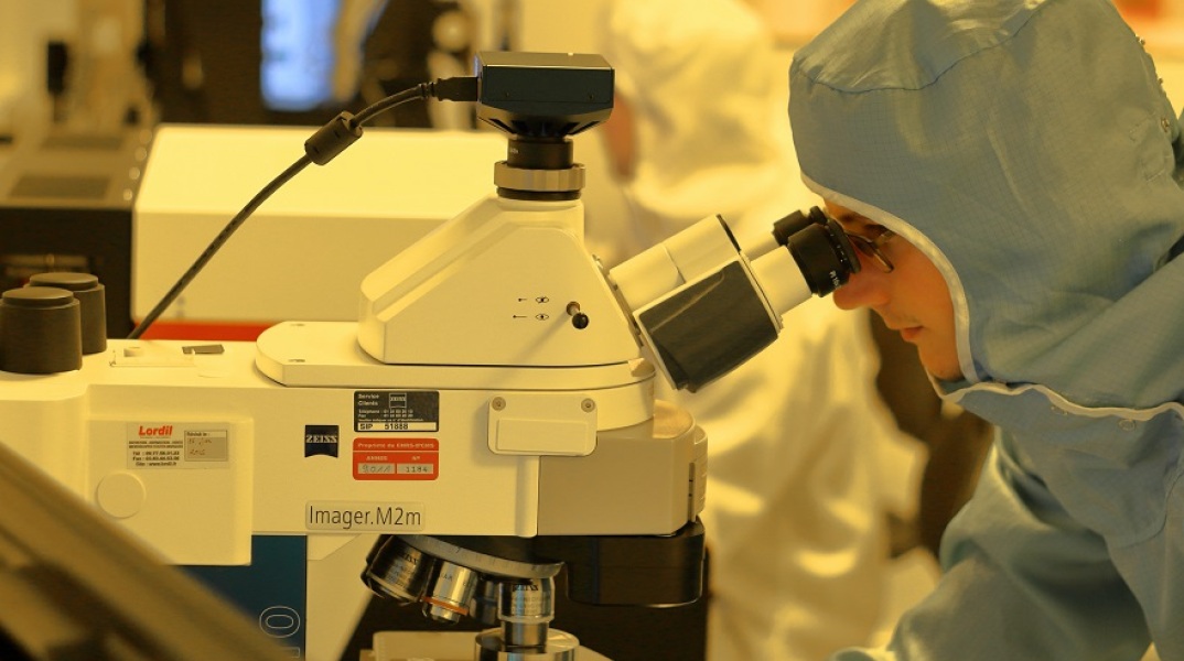 Ερευνητής κοιτά μέσα από το μικροσκόπιο